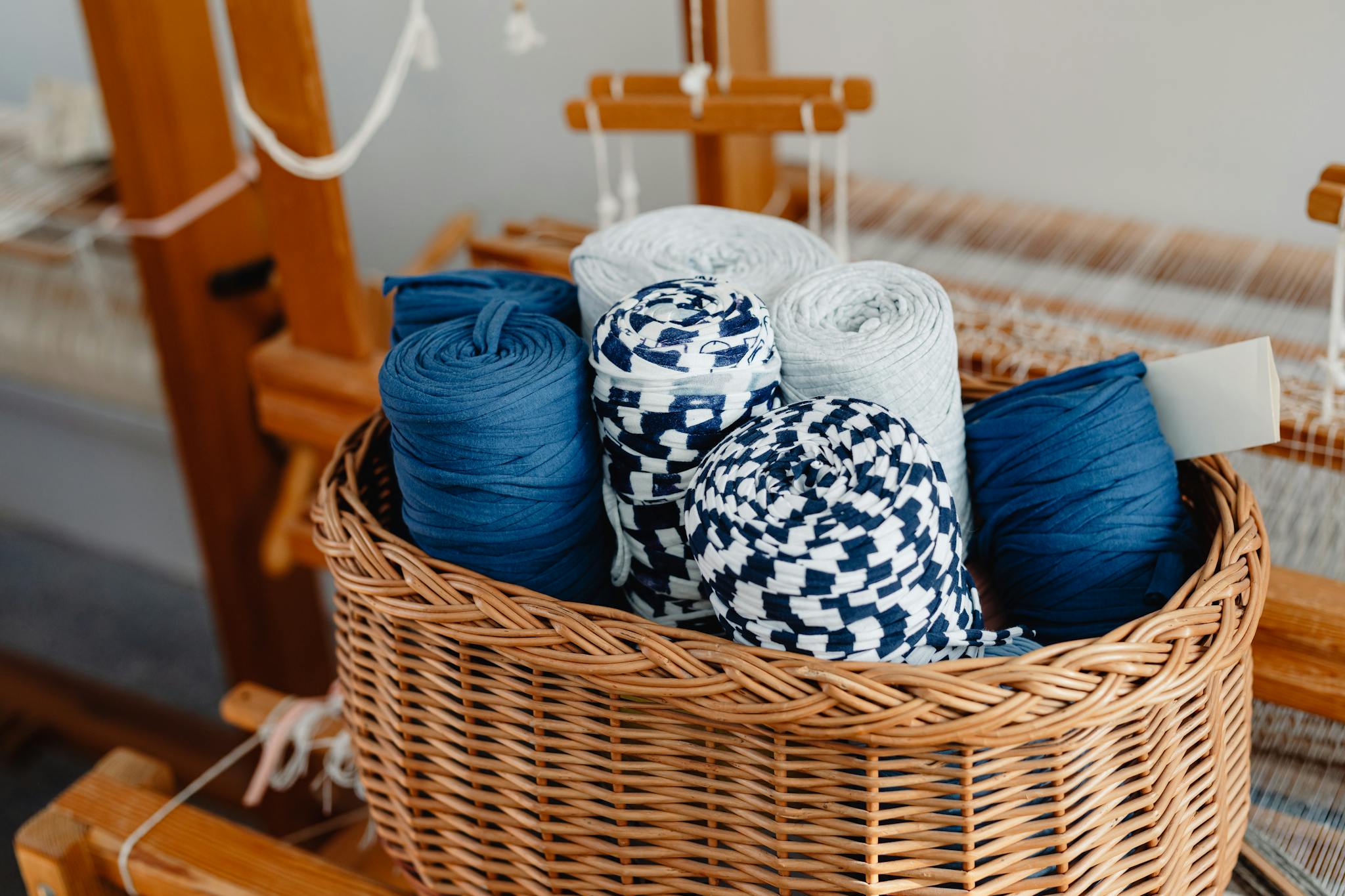 A wicker basket filled with colorful threads on a loom, perfect for arts and crafts enthusiasts.